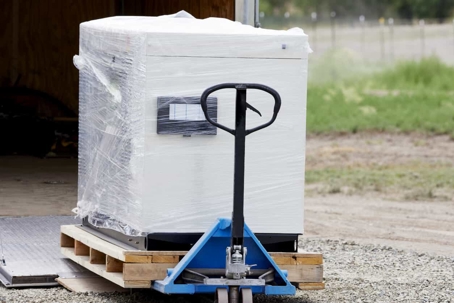 a new generator wrapped in plastic on a trolley