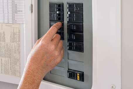 woman turning the circuit breaker on
